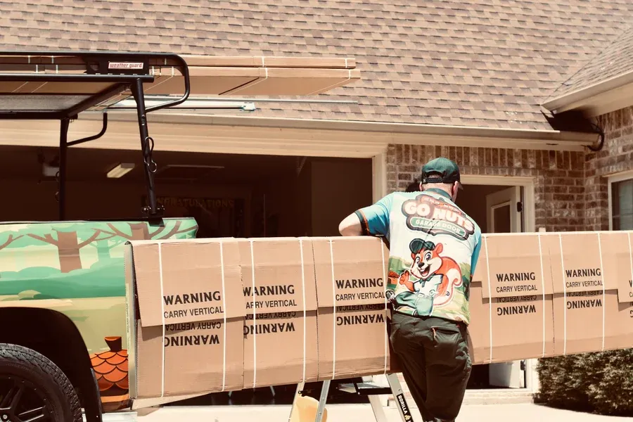 Go Nuts Garage Door technician inspecting a garage door panel in Glen Rose, TX