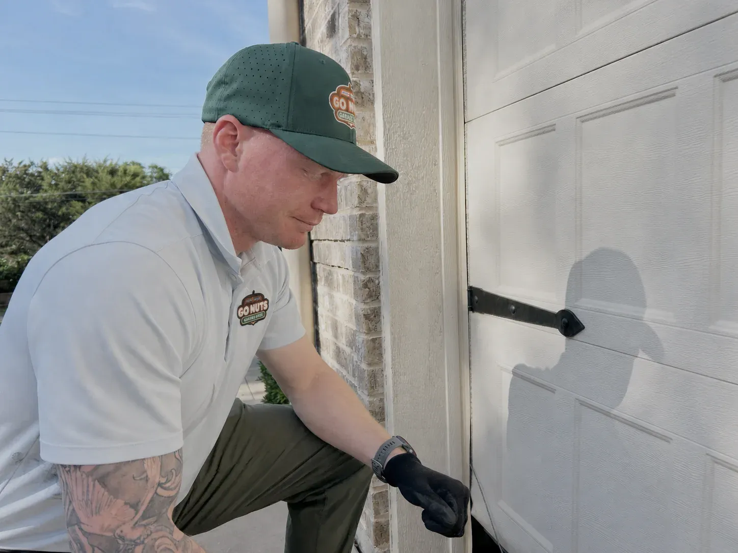 Go Nuts Garage Door technician inspecting a garage door panel in Aledo, TX