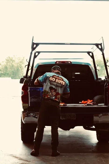 Go Nuts Garage Door technician inspecting a garage door panel in Granbury, TX