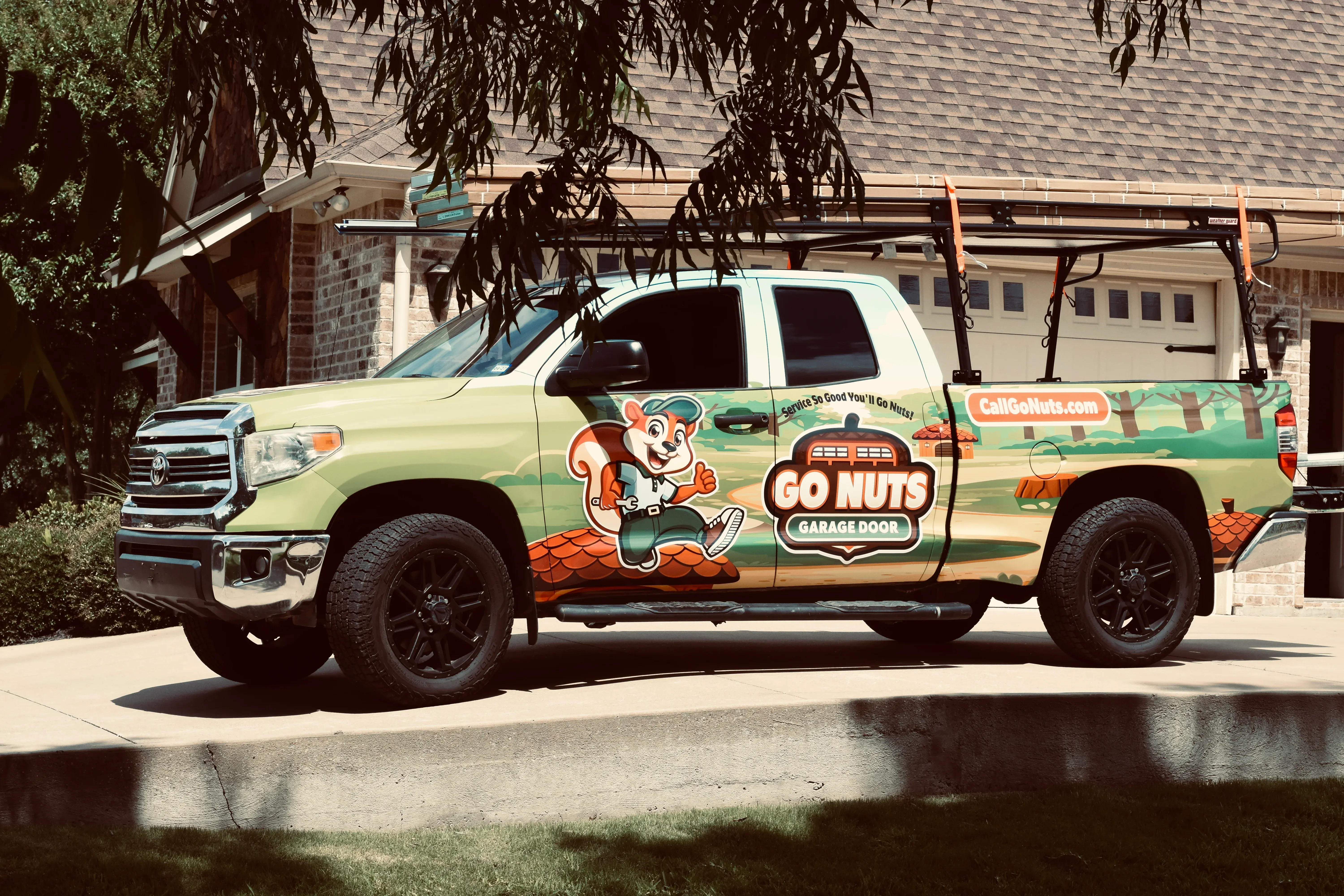 Trey, owner of Go Nuts Garage Door, standing in front of the branded service van in Fort Worth, TX
