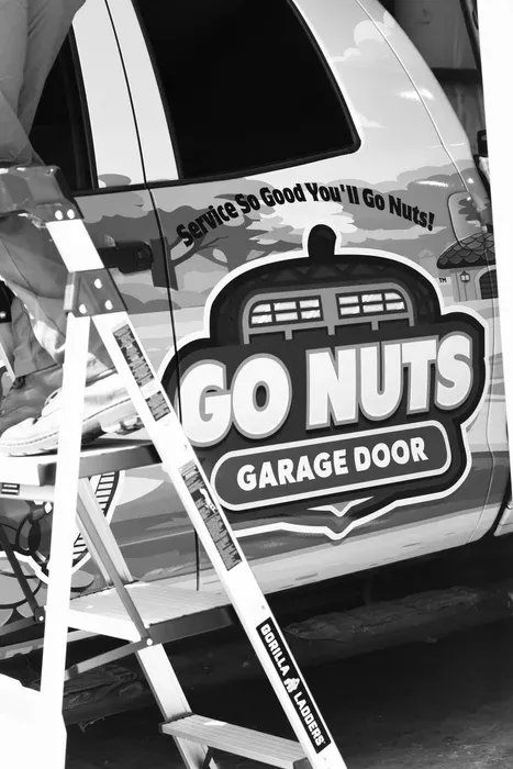 Trey, owner of Go Nuts Garage Door, standing in front of the branded service van in Weatherford, TX